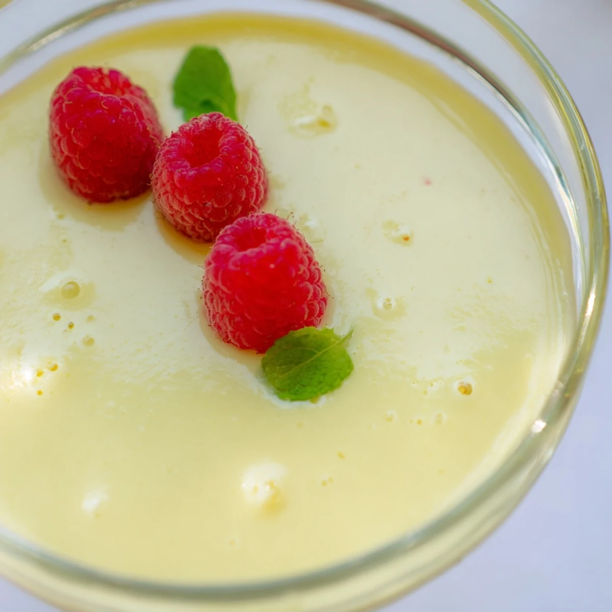 Elegant lemon posset in clear glasses showcasing rich yellow cream and berries