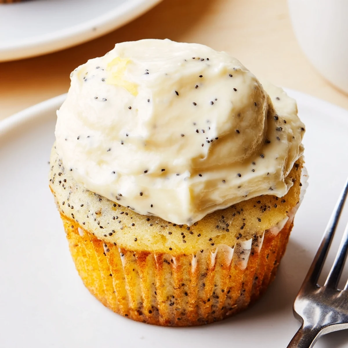 Golden lemon poppy seed cupcakes topped with fluffy cream cheese frosting and zest
