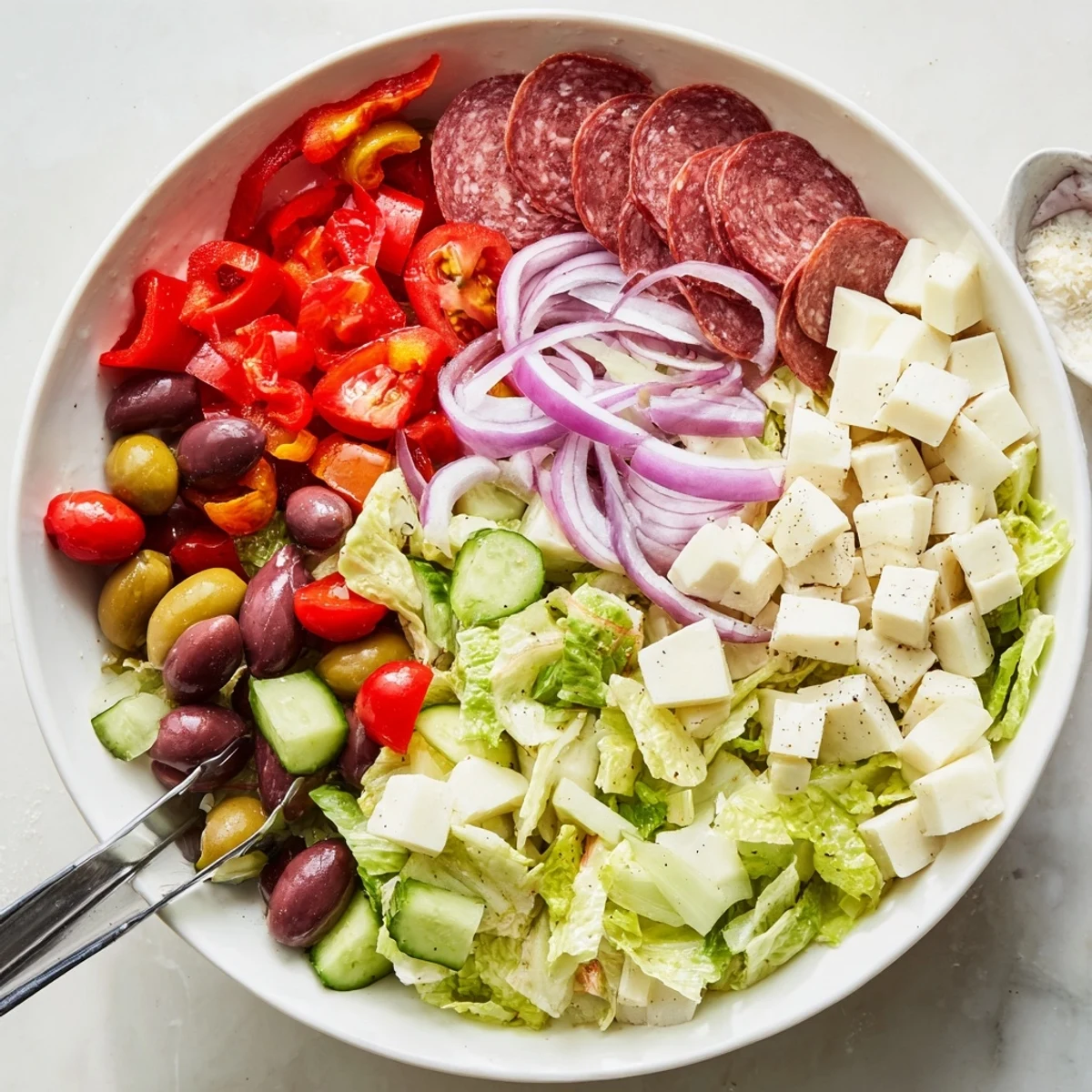 Crisp Italian chopped salad featuring romaine, tomatoes, cured salami, cheese, and pepperoncini tossed in tangy Italian dressing