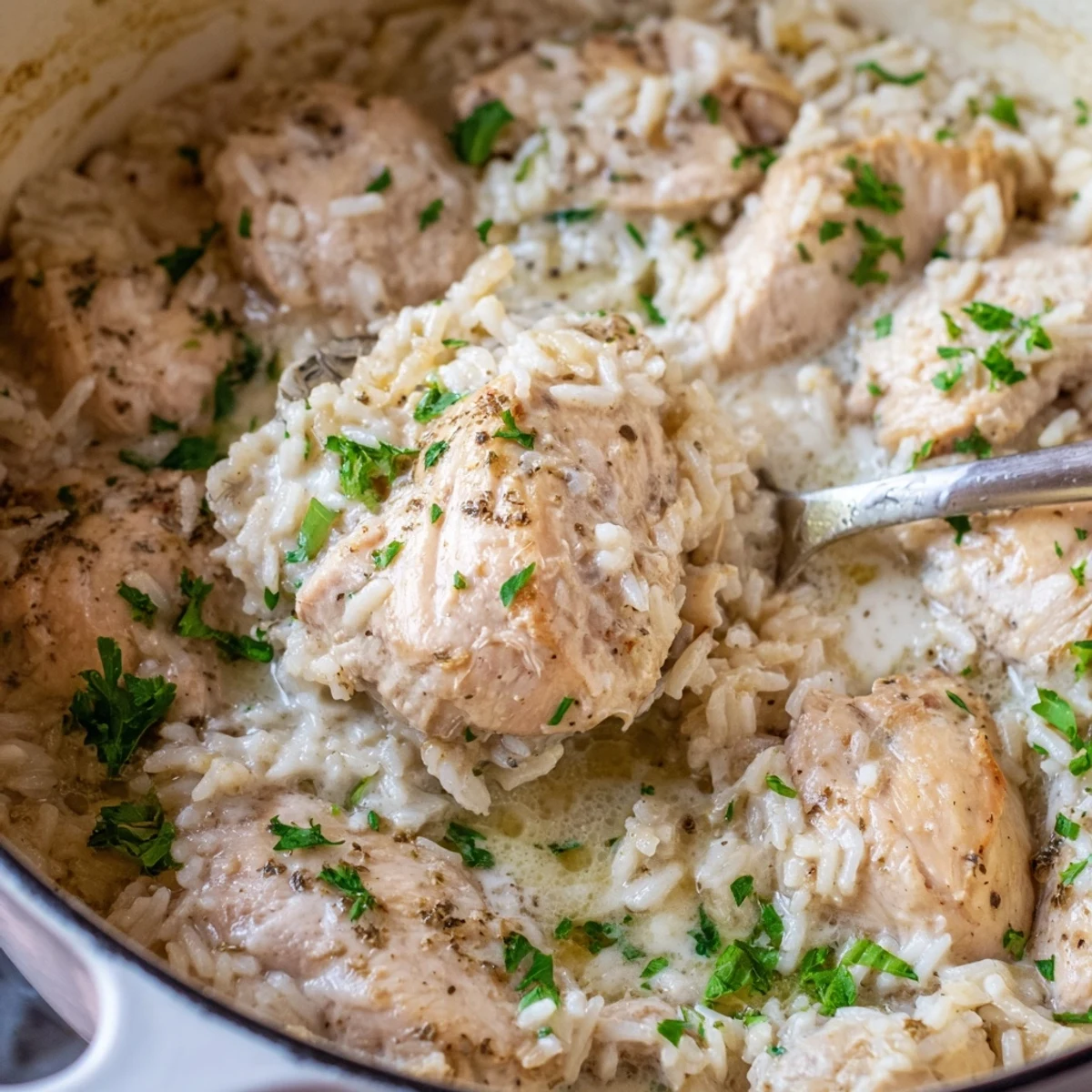 Golden brown chicken breasts rest atop creamy Parmesan rice in this comforting one pot angel chicken bake