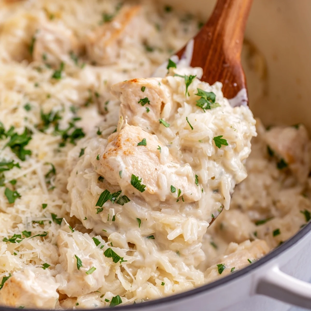 Juicy baked chicken nestled in tender white rice with melted cheese sauce and fresh parsley garnish