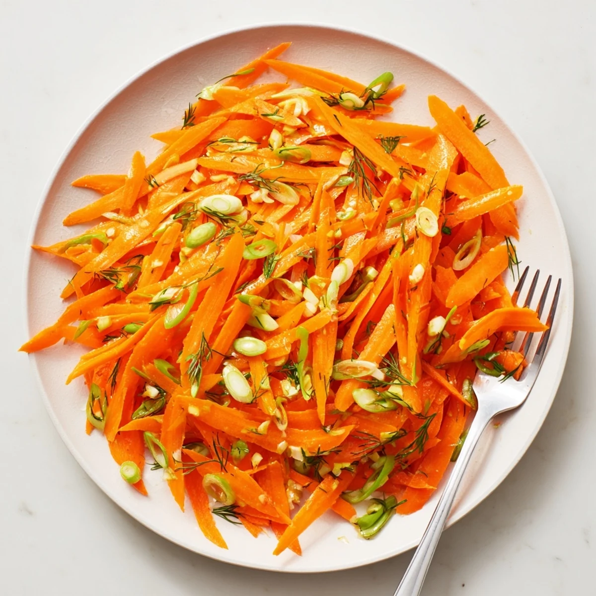 Crisp Marinated Lemon Dill Carrot Salad glistening with bright herb dressing in a serving bowl
