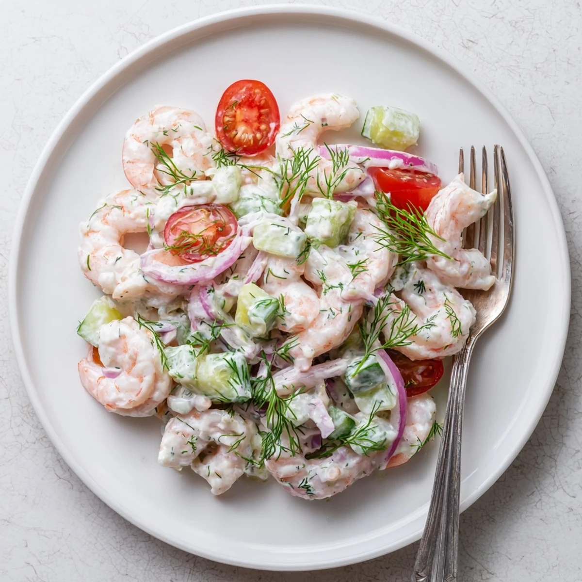 Zesty shrimp salad recipe in a bowl with diced cucumber and red onion