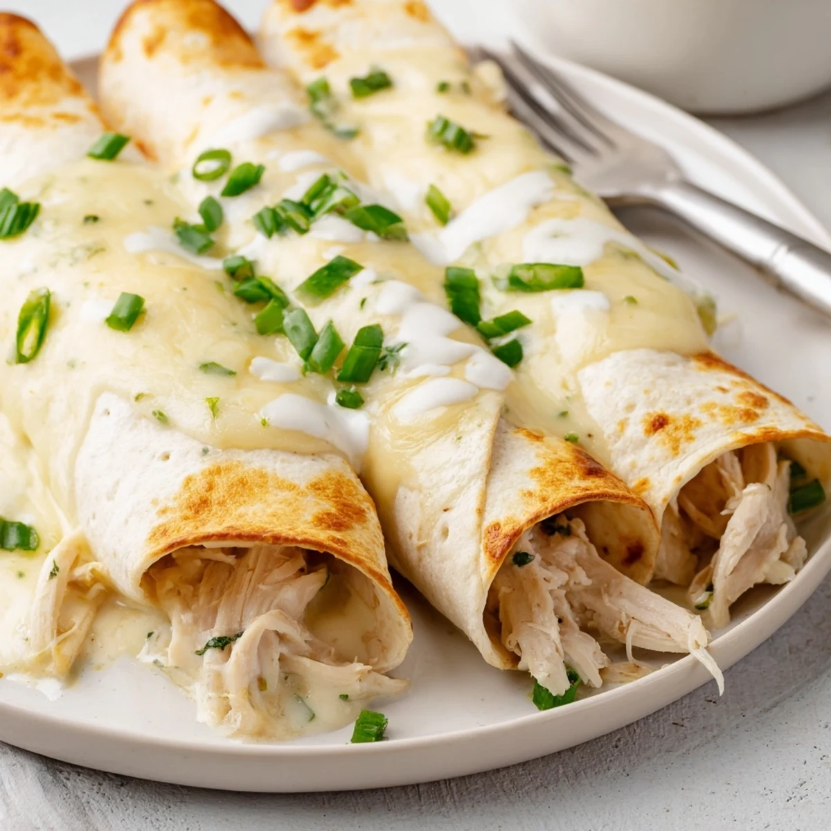 Baked Creamy White Chicken Enchiladas sliced, steam rising, served with Spanish rice
