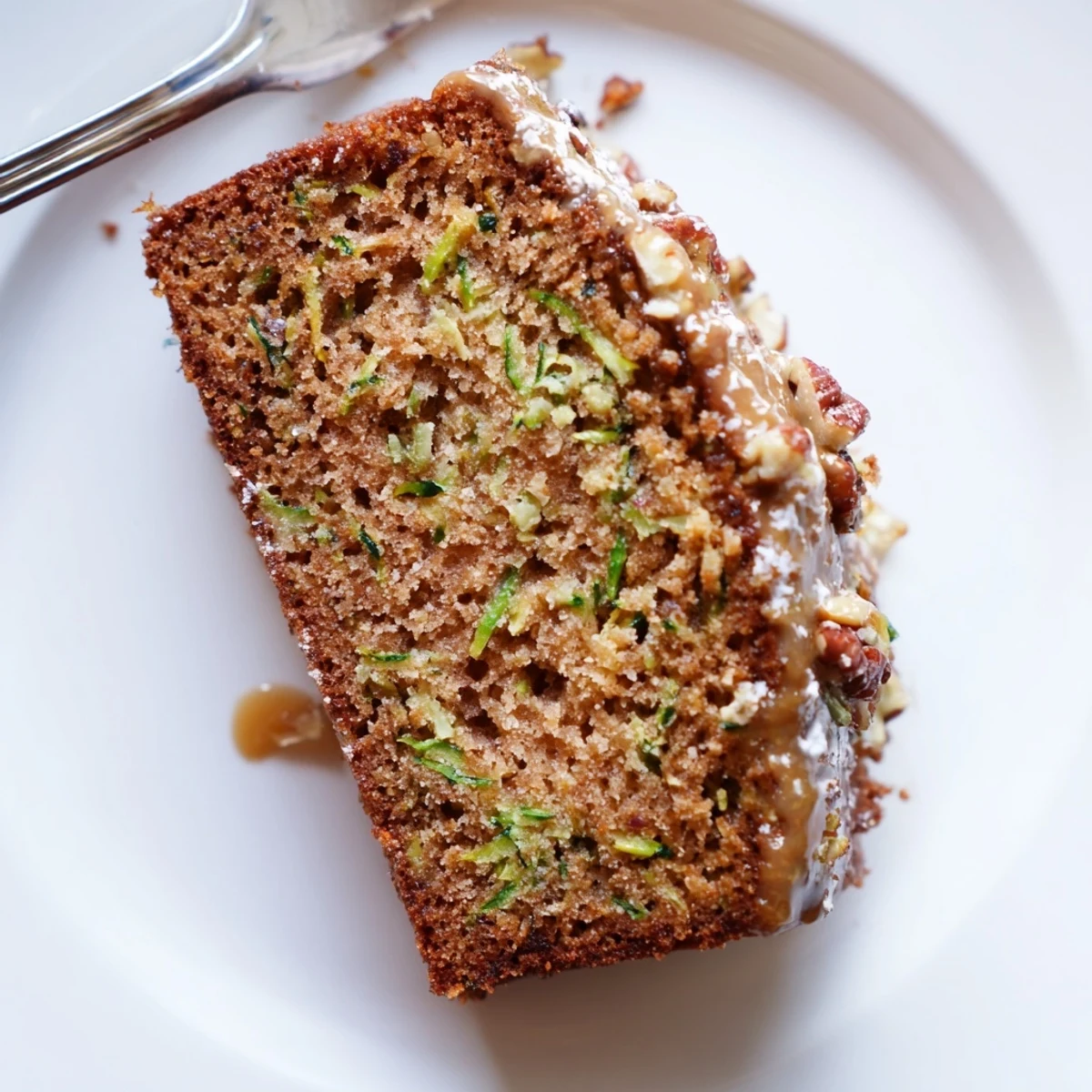 Moist Zucchini Cake With Brown Sugar Icing on a cooling rack, steaming.