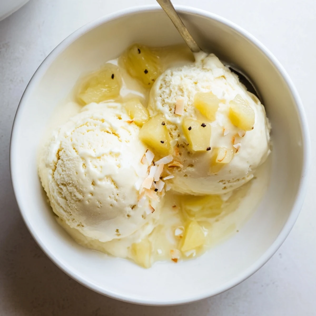 Creamy Pineapple Ice Cream scooped in bowl, tropical aroma and silky texture