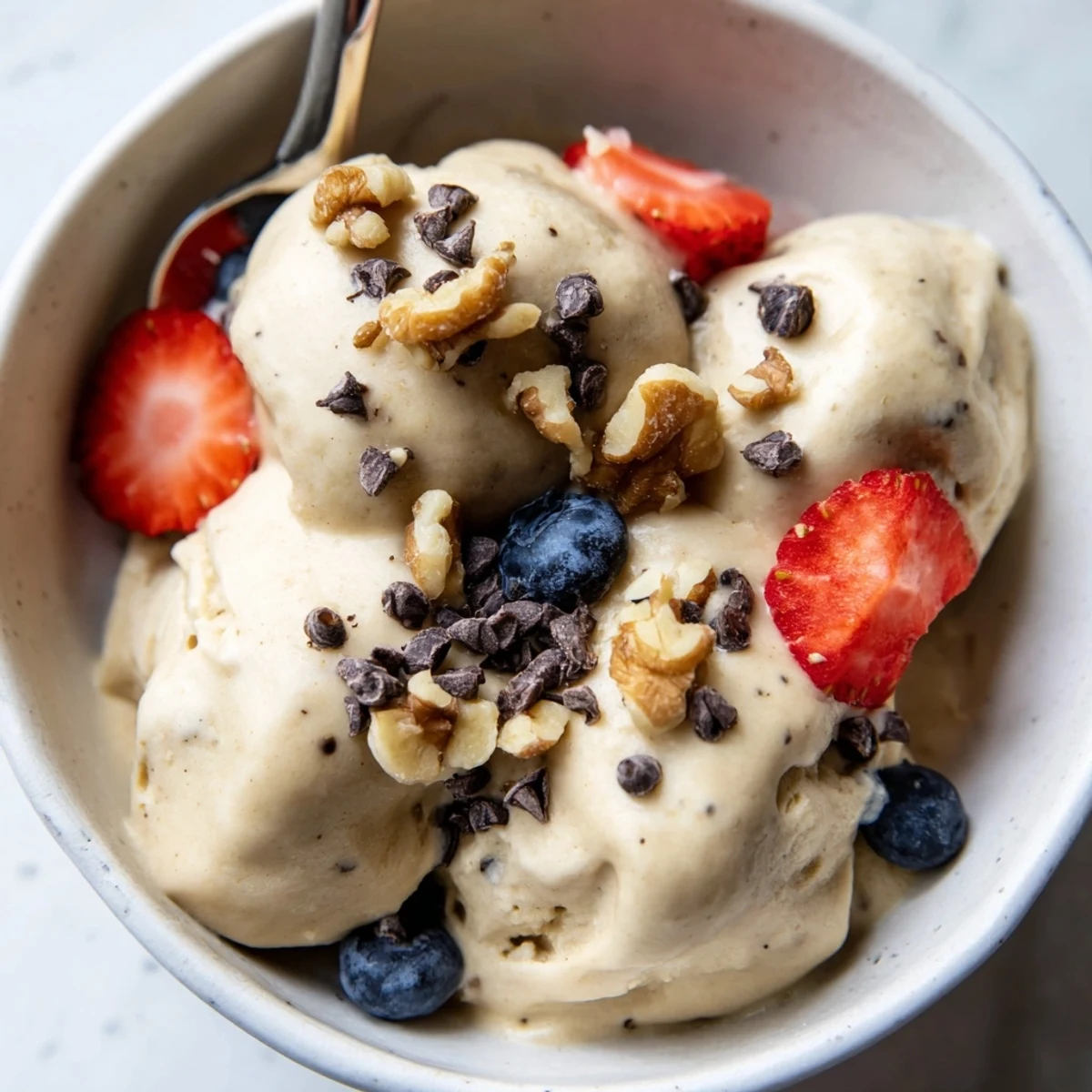 Vegan banana nice cream sprinkled with chocolate chips on a rustic wooden table