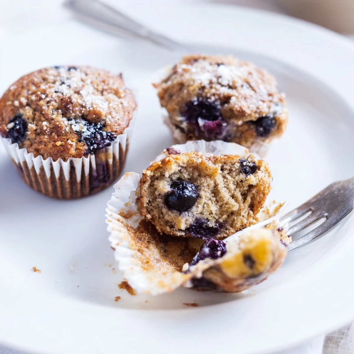Blueberry Banana Muffins with golden tops, steaming beside buttered toast.
