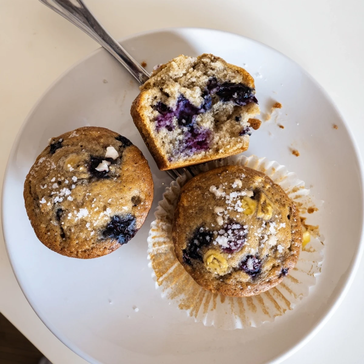 Warm Blueberry Banana Muffins studded with juicy berries, cooling on rack.