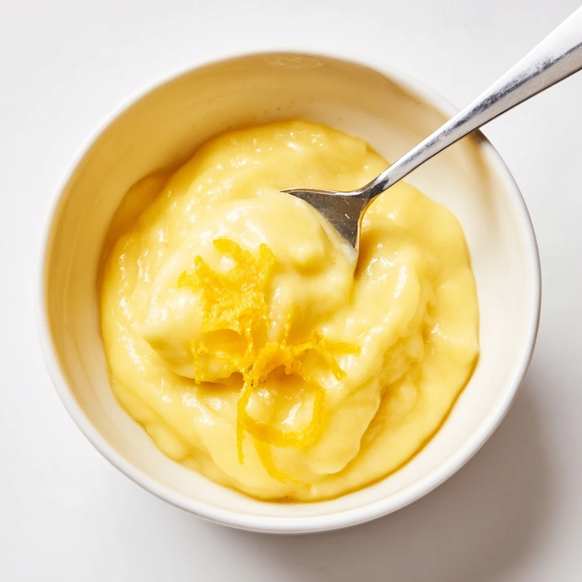 Spoonful of Homemade Lemon Curd drizzling over warm scone, bright tang.