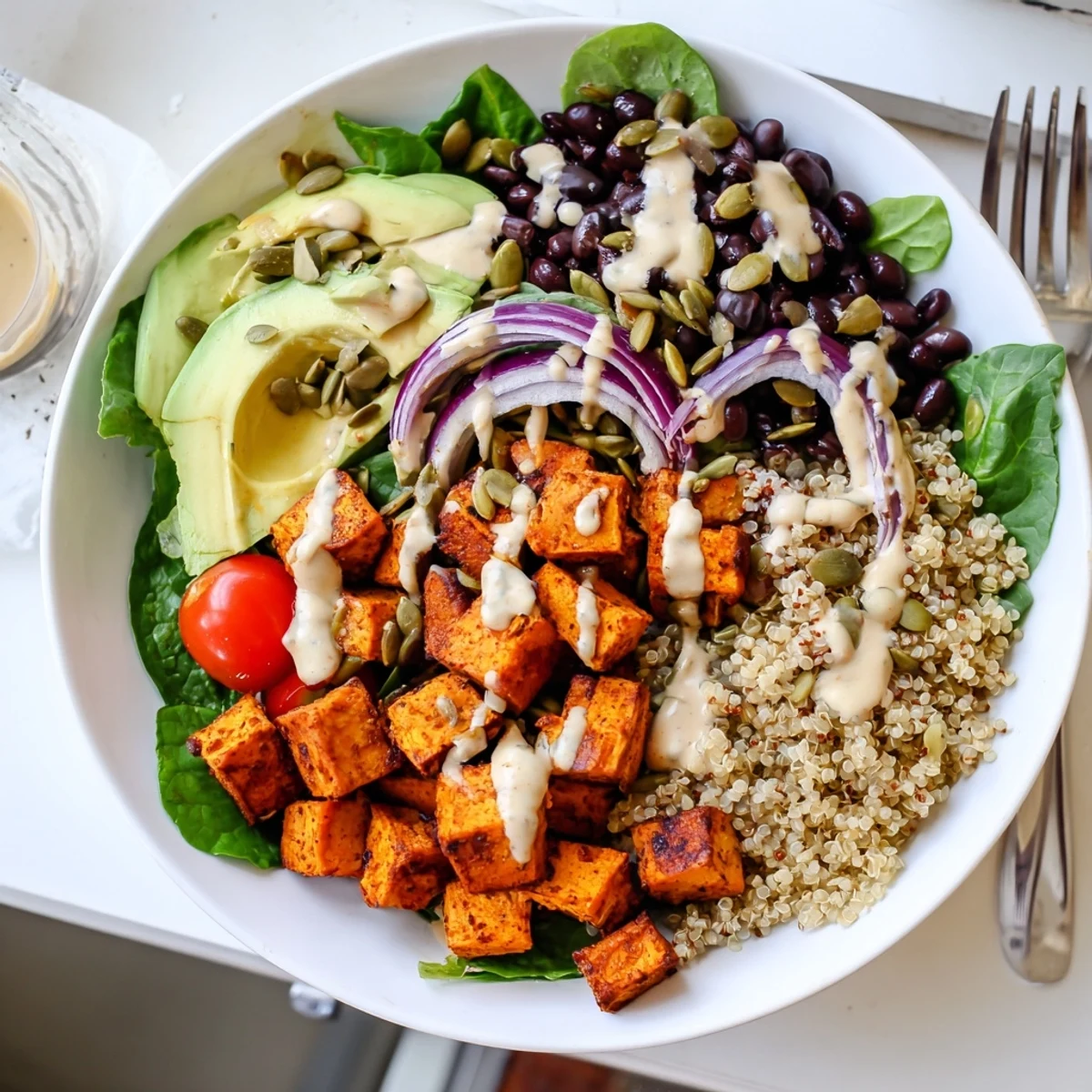Colorful sweet potato bowl with caramelized cubes, quinoa, and crisp cherry tomatoes
