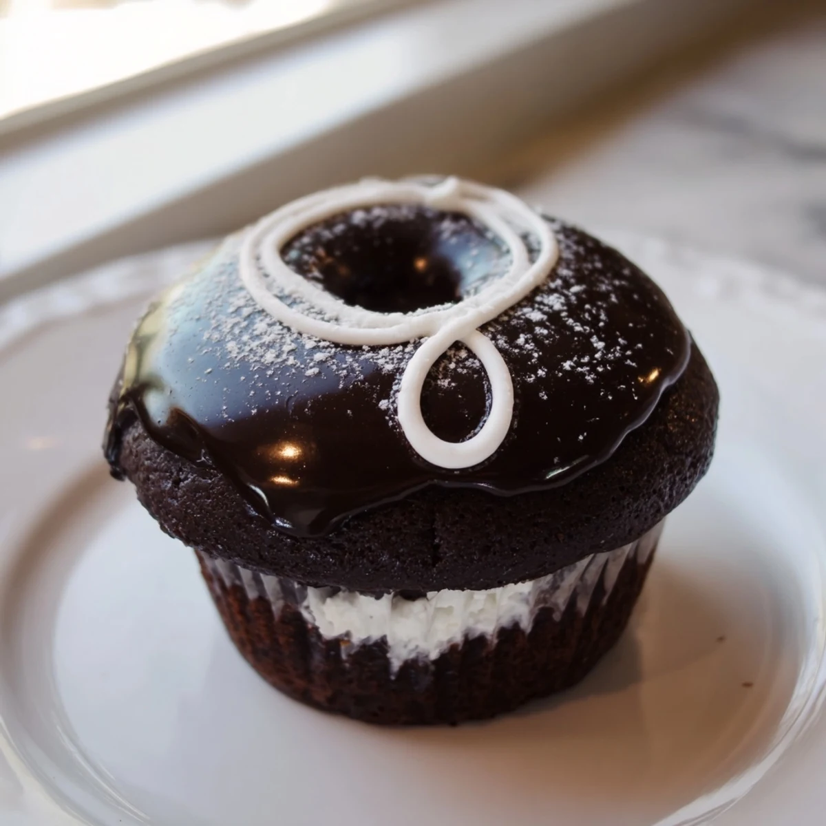 Freshly glazed Homemade Hostess Cupcakes topped with a classic white icing swirl