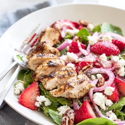Tangy poppy seed dressing drizzled over a colorful Strawberry Chicken Salad featuring toasted pecans and greens